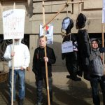 Marsz weteranów Legionu Łotewskiego SS w Rydze, symbole przeciwko totalitaryzmom i przeciwnicy marszu.