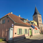 Najstarszy budynek w mieście i dalej wieża kościoła św. Jana. Widoczna flaga Estonii i biało-czerwona flaga Tartu. Zdj. Kazimierz Popławski.