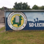 Mural „upamiętniający” rocznicę 50-lecia szczecińskiej Spółdzielni Mieszkaniowej „Dąb” (ul. Fioletowa) z efektownym pejzażem stoczniowym. Zdj. Jakub Michał Pawłowski.
