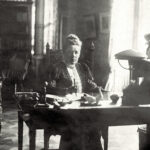 Selma Lagerlöf przy swoim biurku. Na biurku stoją dwie małe ceramiczne gęsi. 1909 r. Zdj. CC0.